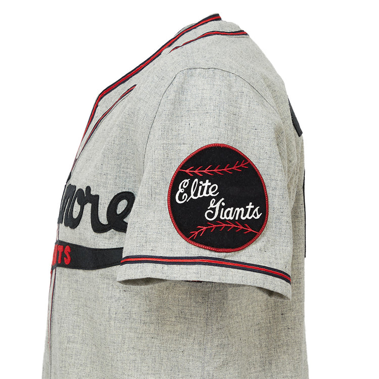 The EFF Baltimore Elite Giants 1949 Road Jersey is a gray short-sleeve jersey with black and red trim, partial black chest text, and a round black Elite Giants patch on the sleeve honoring the Negro National League.