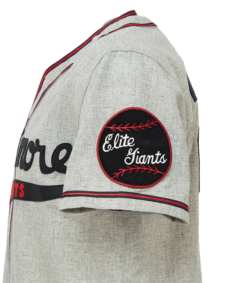 The EFF Baltimore Elite Giants 1949 Road Jersey is a gray short-sleeve jersey with black and red trim, partial black chest text, and a round black Elite Giants patch on the sleeve honoring the Negro National League.