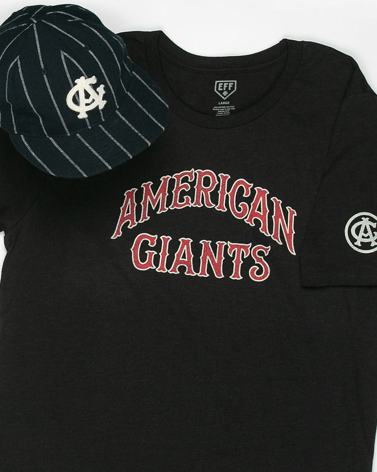 A black Chicago American Giants T-Shirt by EFF with red and white lettering and a sleeve logo patch sits beside a navy pinstriped cap with a white overlapping logo, celebrating the legacy of Black baseball.