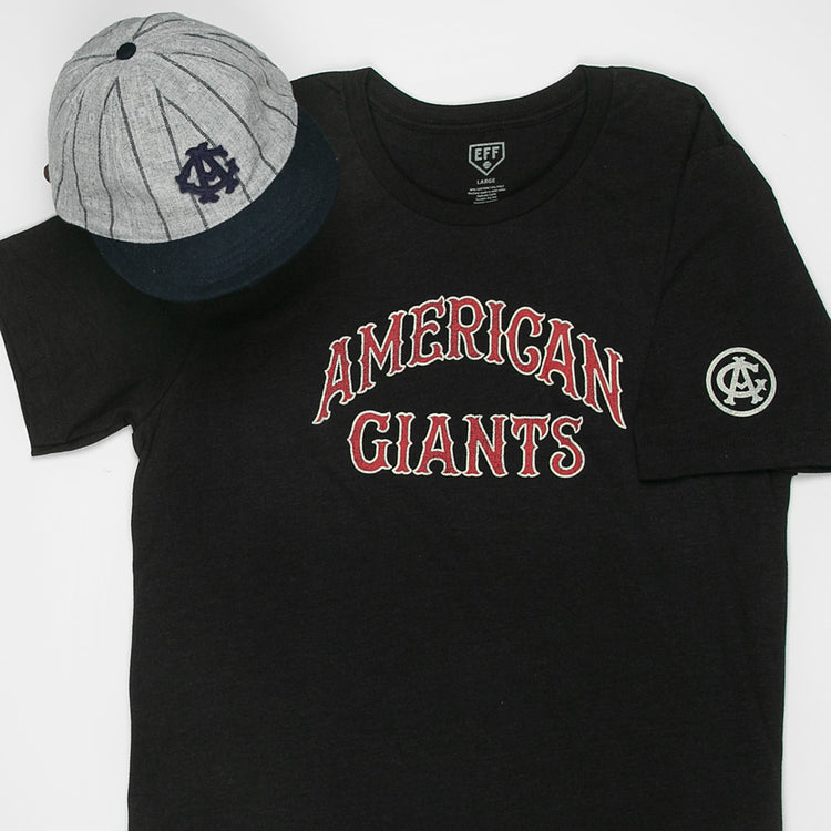 The EFF Chicago American Giants T-Shirt in black features red and white lettering and a sleeve emblem, shown beside a gray and navy blue baseball cap with an AG logo—both honoring Negro League Black baseball history.