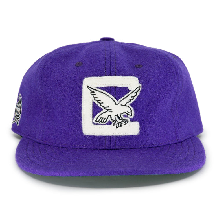 The EFF Cleveland Falcons 1936 Vintage Ballcap is a purple wool cap featuring a large white C and embroidered falcon on the front, a circular patch on the left side, and an adjustable leather strap for a perfect fit.