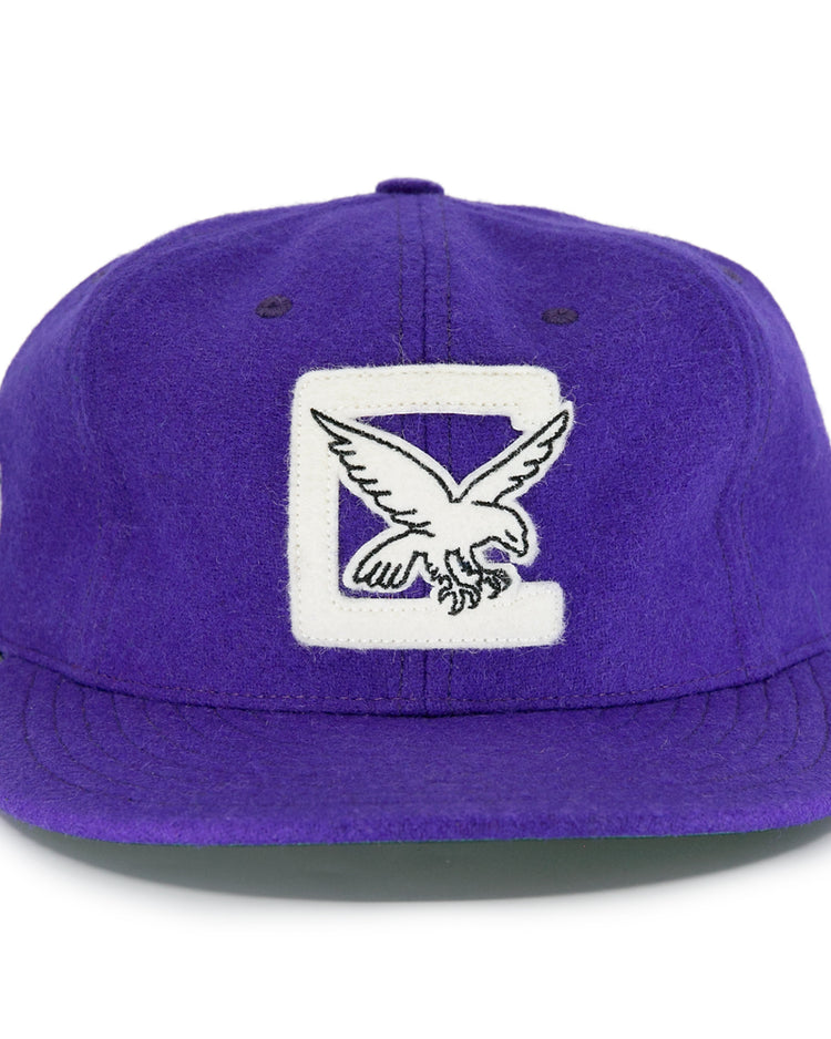 The EFF Cleveland Falcons 1936 Vintage Ballcap is a purple wool cap featuring a large white C and embroidered falcon on the front, a circular patch on the left side, and an adjustable leather strap for a perfect fit.