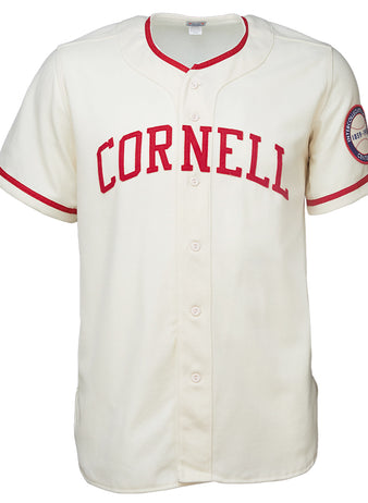 The EFF Cornell University 1959 Home Jersey is a cream baseball jersey with red trim, bold red CORNELL lettering on the chest, and a round patch on the left sleeve—a classic vintage collegiate style.