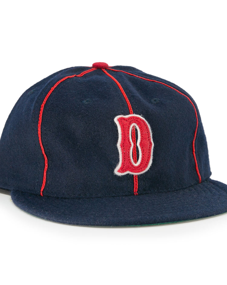 The EFF Danville Veterans 1932 Vintage Ballcap is a navy blue wool hat with red piping, a red and white outlined letter D, flat brim, and classic red button—ideal for collectors of historic ballcaps.
