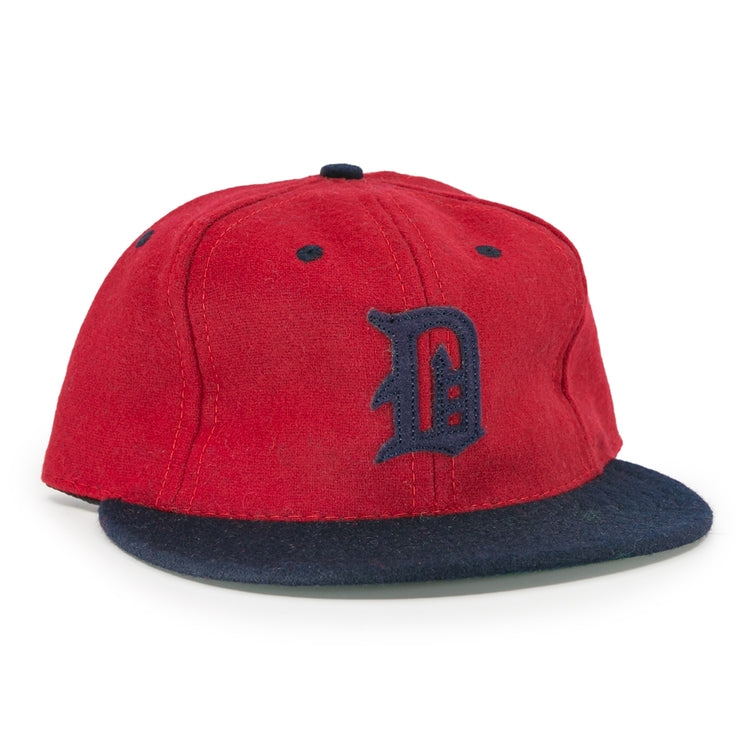 The EFF Deland Red Hats 1939 Vintage Ballcap features genuine wool, a red crown, dark blue brim, and a stylized dark blue D—a classic design inspired by the original Deland Red Hats baseball cap.