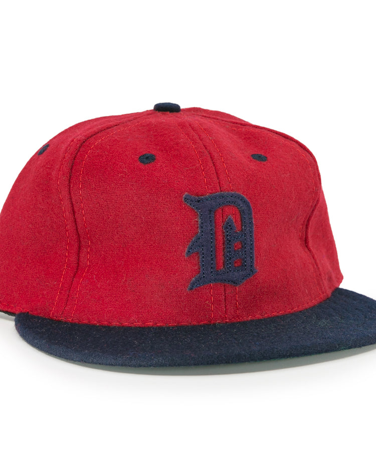 The EFF Deland Red Hats 1939 Vintage Ballcap features genuine wool, a red crown, dark blue brim, and a stylized dark blue D—a classic design inspired by the original Deland Red Hats baseball cap.