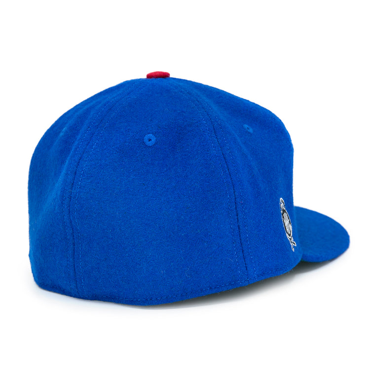 The EFF Detroit Olympics Vintage Ballcap, shown in royal blue wool with a red top button, has an embroidered International Hockey League logo on the right and a visible adjustable leather strap, displayed on a white surface.