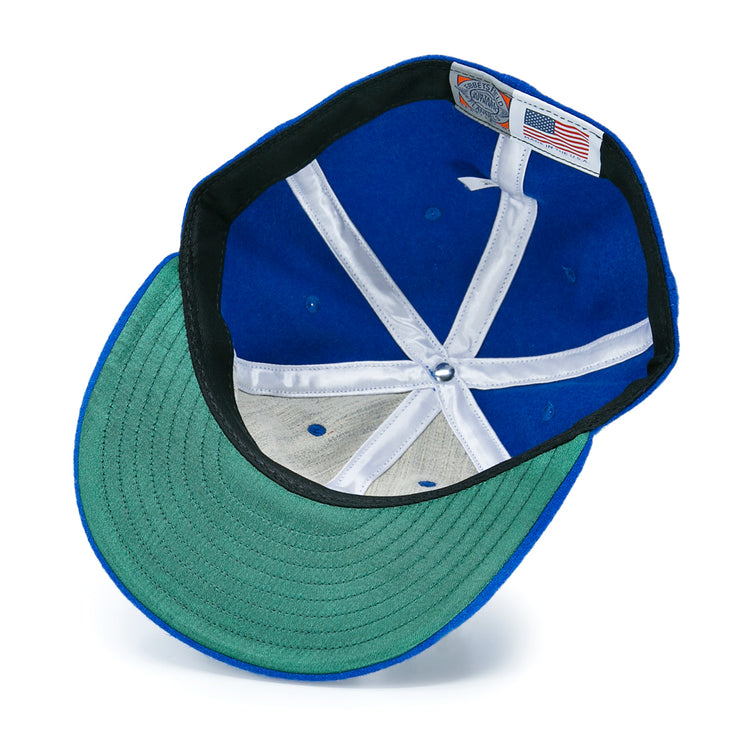 The Detroit Olympics Vintage Ballcap by EFF features blue vintage wool, a green underbrim, white interior lining strips, an adjustable leather strap, and a tag with the American flag and brand details visible beneath.