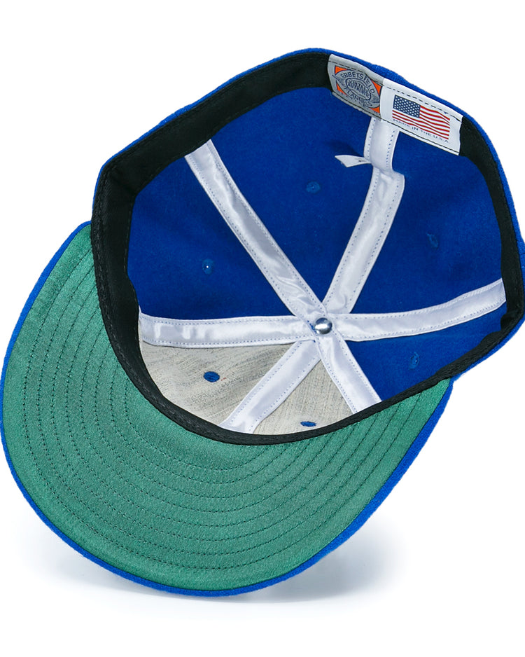 The Detroit Olympics Vintage Ballcap by EFF features blue vintage wool, a green underbrim, white interior lining strips, an adjustable leather strap, and a tag with the American flag and brand details visible beneath.