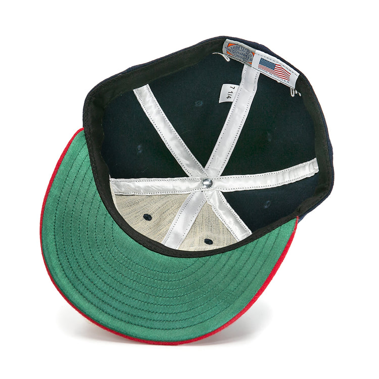 An overhead view of the Larry Doby Signature Series Ballcap by Ebbets Field Flannels shows green fabric under the brim, a red edge, white lining strips, a size tag, and an American flag label inside.