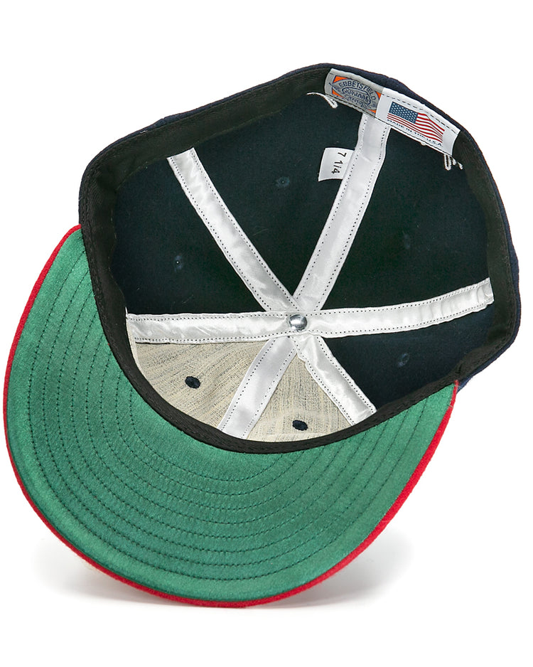 An overhead view of the Larry Doby Signature Series Ballcap by Ebbets Field Flannels shows green fabric under the brim, a red edge, white lining strips, a size tag, and an American flag label inside.