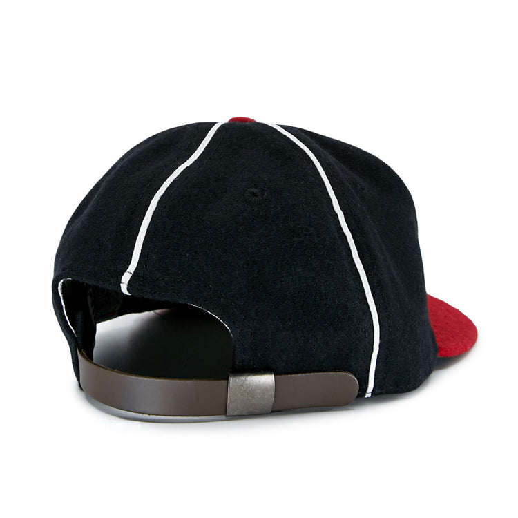 The EFF Escogido Leones 1952 Vintage Ballcap features a black design with white piping, a red brim, and an adjustable brown leather strap with metal clasp, shown here from the rear.
