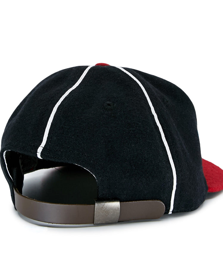 The EFF Escogido Leones 1952 Vintage Ballcap features a black design with white piping, a red brim, and an adjustable brown leather strap with metal clasp, shown here from the rear.