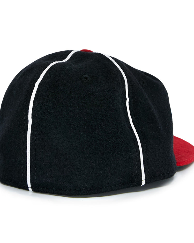 The EFF Escogido Leones 1952 Vintage Ballcap is a black cap with two white vertical stripes and a red brim, shown from the back.