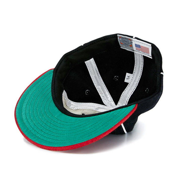 A look inside the EFF Escogido Leones 1952 Vintage Ballcap shows a green underbill, red brim trim, white interior seams, ventilation holes, and an American flag tag next to a size label reading 7 1/4.