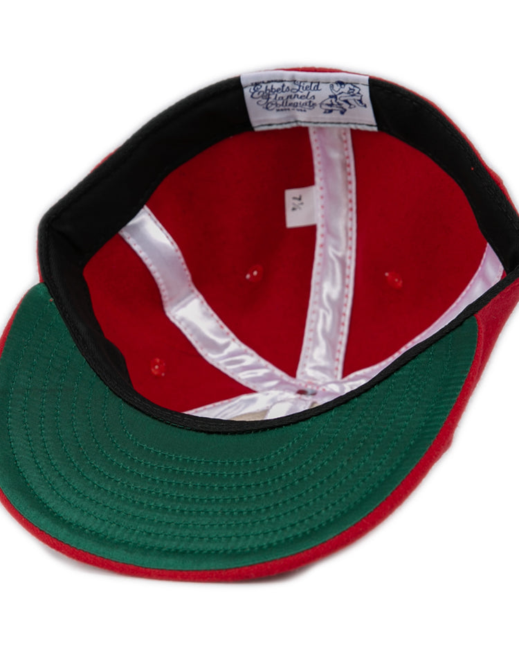 The Ebbets Field Flannels Fresno State University 1951 Vintage Ballcap is shown from above, revealing its white satin lining, sweatband with visible stitching, a top label, and a green underside on the authentic wool brim.