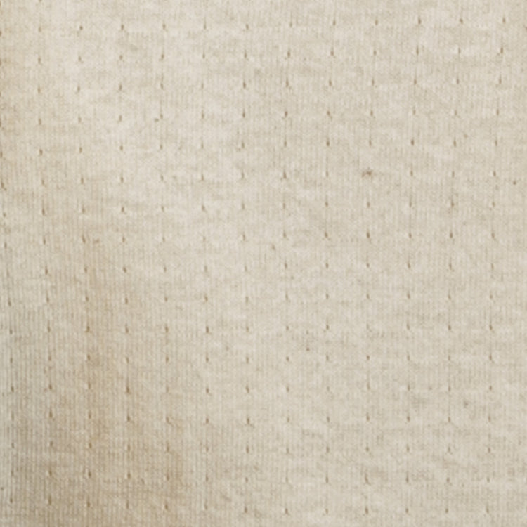 Close-up of the EFF Fungo Shirt, featuring a beige, textured knit fabric with a subtle grid of small raised dots. The soft material recalls vintage wool blends, while black sleeves and logo add a modern touch.