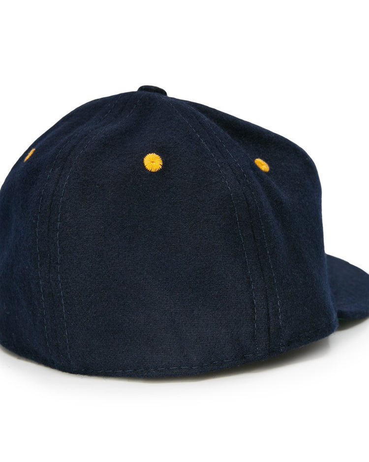 The EFF Great Lakes Naval Station 1944 Vintage Ballcap is shown from the back, showcasing navy wool, yellow embroidered eyelets on each panel, and visible stitching.