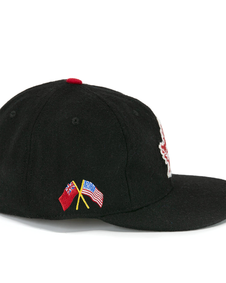 The EFF Galt Terriers 1961 Vintage Ballcap is a black wool baseball cap with crossed British Red Ensign and American flag embroidery, red top button, and flat brim—ideal for Ontario Senior Hockey League or Allan Cup fans.