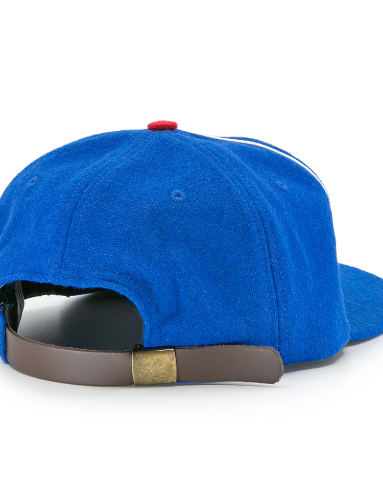 The Houston Buffs 1960 Vintage Ballcap by EFF is shown from the back, featuring a brown adjustable strap with brass clasp. Made of genuine wool baseball cloth, it has a red top button and curved brim.