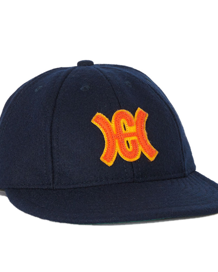 The Hiroshima Carp 1959 Vintage 8-panel Ballcap by Ebbets Field Flannels features a navy blue design with a yellow and red embroidered mirrored H and C logo, inspired by the iconic Japanese baseball team.