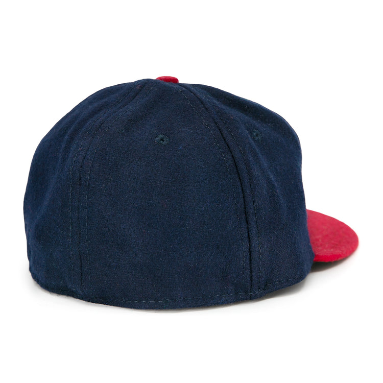 The Ebbets Field Flannels Jacksonville Braves 1953 Vintage Ballcap features soft navy fabric with a red brim, visible panel stitching, and is shown from the back at an angle—capturing the classic look of the original.