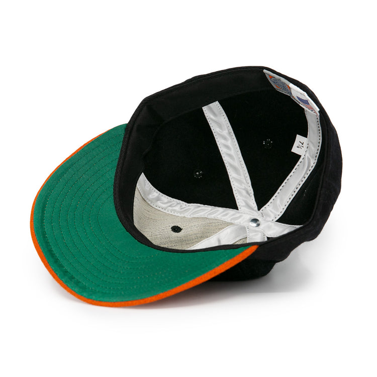 The EFF Jersey City Skeeters 1928 Vintage Ballcap is shown from the inside, displaying a green brim underside with an orange edge and white inner lining with visible stitching.