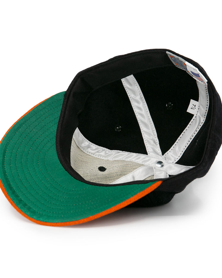 The EFF Jersey City Skeeters 1928 Vintage Ballcap is shown from the inside, displaying a green brim underside with an orange edge and white inner lining with visible stitching.