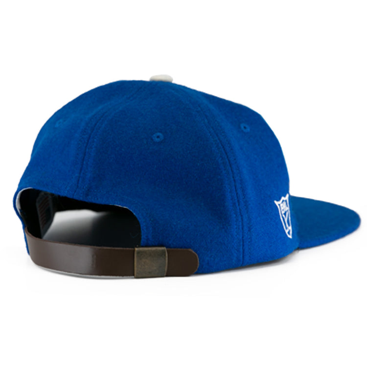 The EFF Johnstown Jets 1970 Vintage Ballcap in blue wool features a back view, adjustable leather strap with metal clasp, and a white embroidered side logo—ideal for Eastern Hockey League fans.