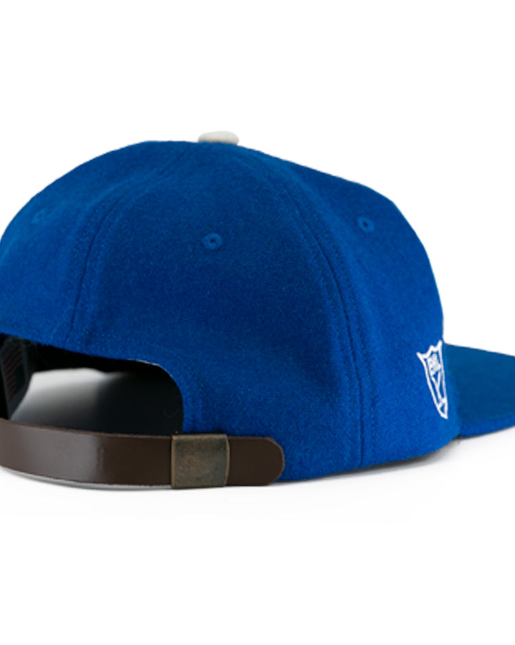 The EFF Johnstown Jets 1970 Vintage Ballcap in blue wool features a back view, adjustable leather strap with metal clasp, and a white embroidered side logo—ideal for Eastern Hockey League fans.