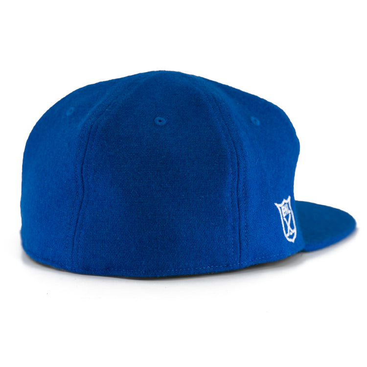 The EFF Johnstown Jets 1970 Vintage Ballcap in royal blue wool is shown from the back and side, featuring a small white embroidered shield logo on the lower right and an adjustable leather strap for a timeless look.