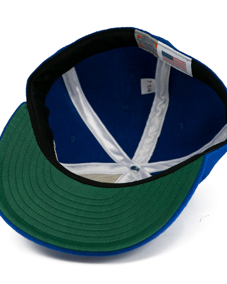The image shows the interior of an EFF Johnstown Jets 1970 Vintage Ballcap, featuring a blue wool exterior, green brim underside, white inner seams, a “7 1/4” size tag, and an American flag label.