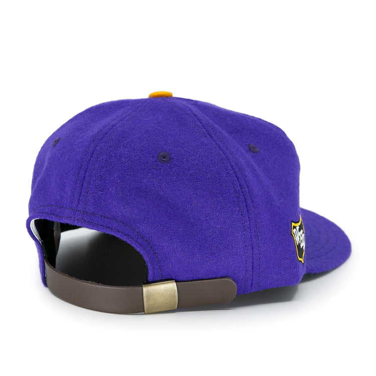 The EFF Los Angeles Monarchs 1947 Vintage Ballcap is a purple wool hat with a brown adjustable strap, gold buckle, and a side embroidered patch, inspired by classic LA Monarchs designs.