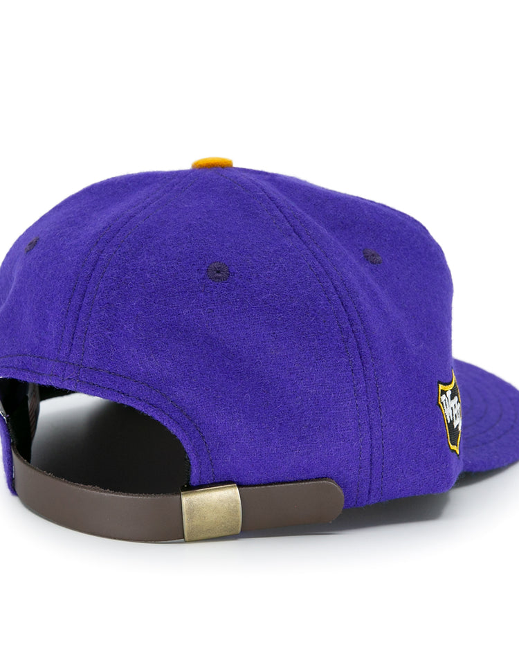 The EFF Los Angeles Monarchs 1947 Vintage Ballcap is a purple wool hat with a brown adjustable strap, gold buckle, and a side embroidered patch, inspired by classic LA Monarchs designs.