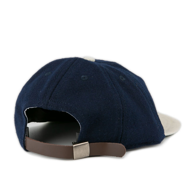 The EFF Larrupin’ Lou’s 1927 Vintage 8-Panel Ballcap features navy blue fabric, a curved brim, and a tan adjustable leather strap at the back, shown against a white background.