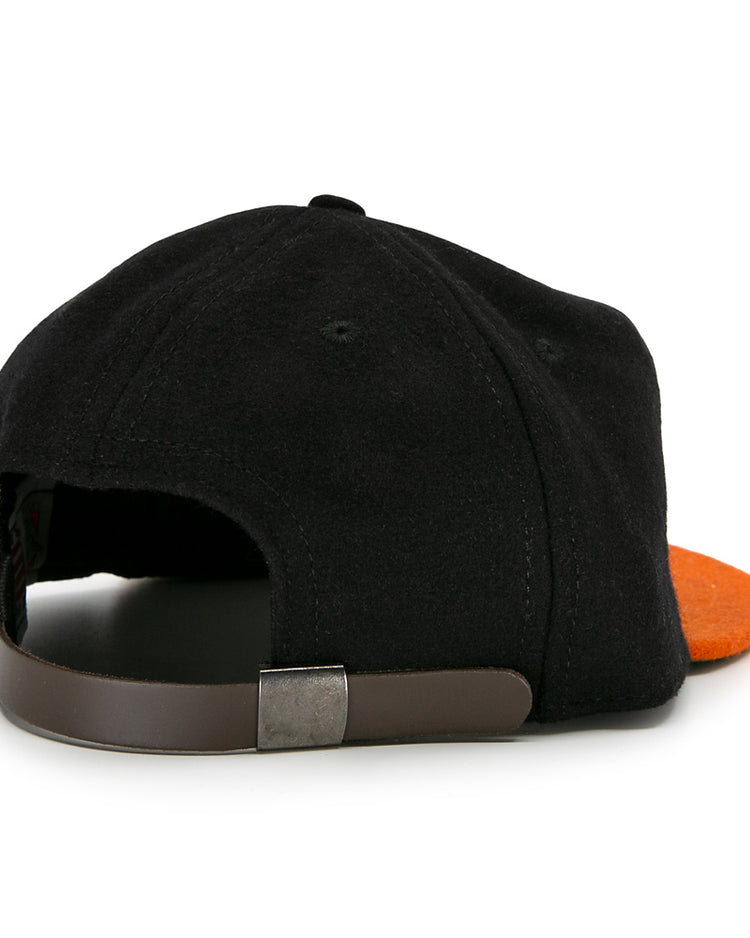 The Marianao Tigres 1950 Vintage Ballcap by Ebbets Field Flannels features a black and orange design, classic brown adjustable strap with metal clasp, and is inspired by the Cuban Professional League.