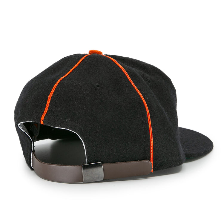 The EFF Montreal Black Panthers 1936 Vintage Ballcap features a black design with orange seams, a dark brown adjustable strap with metal clasp, and a slightly curved brim—classic details inspired by the original 1936 team cap.