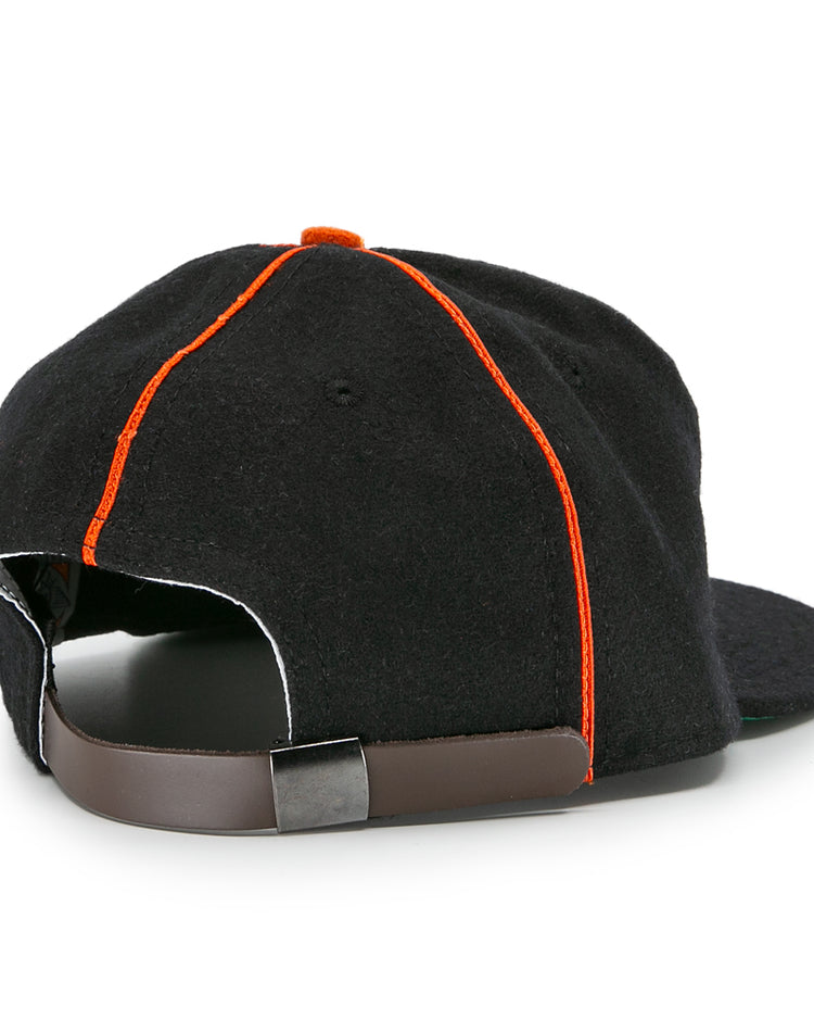 The EFF Montreal Black Panthers 1936 Vintage Ballcap features a black design with orange seams, a dark brown adjustable strap with metal clasp, and a slightly curved brim—classic details inspired by the original 1936 team cap.