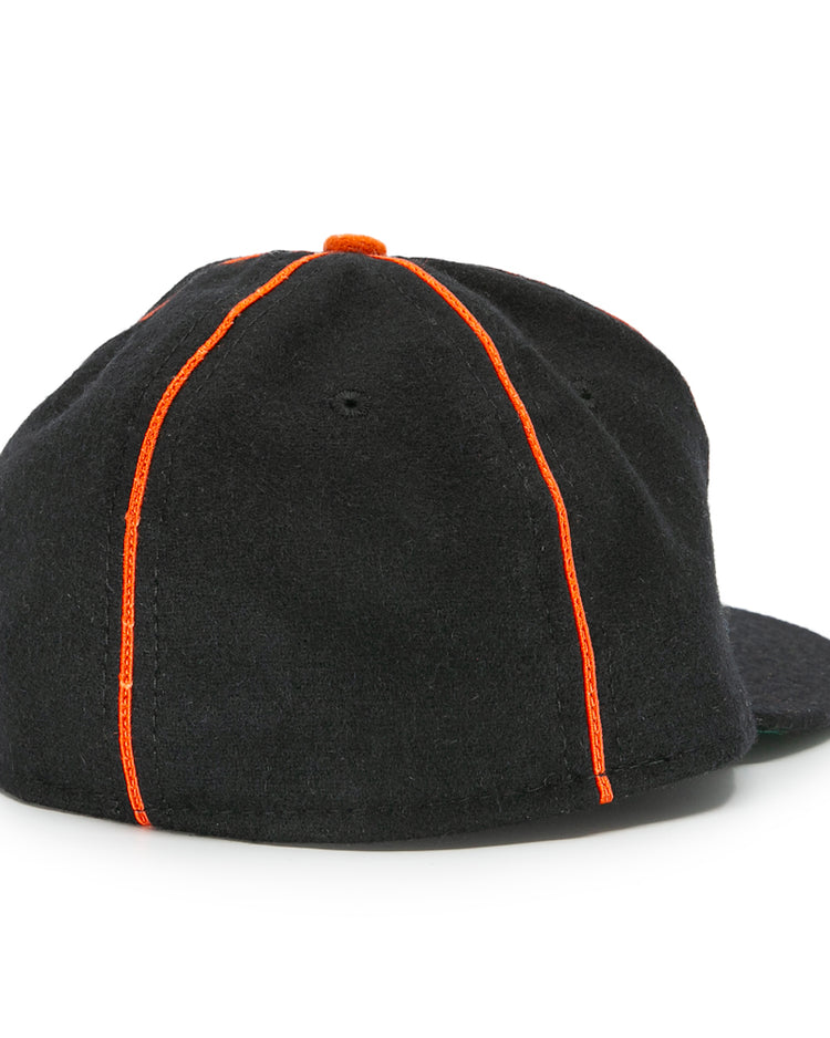 The EFF Montreal Black Panthers 1936 Vintage Ballcap in black is shown from the back, featuring orange seam stitching and a small orange top button, inspired by classic Quebec Provincial League baseball cap styles.