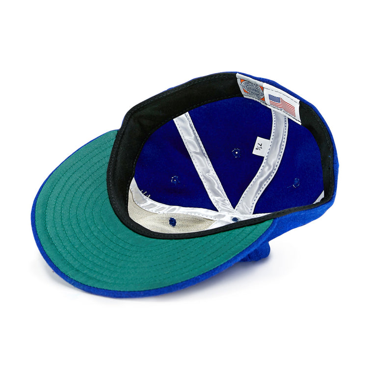 The EFF Memphis Red Sox 1944 Vintage Ballcap is shown upside down, revealing its green brim underside, black band, white interior labels, silver lining, and an American flag tag—just like the classic Negro American League style.