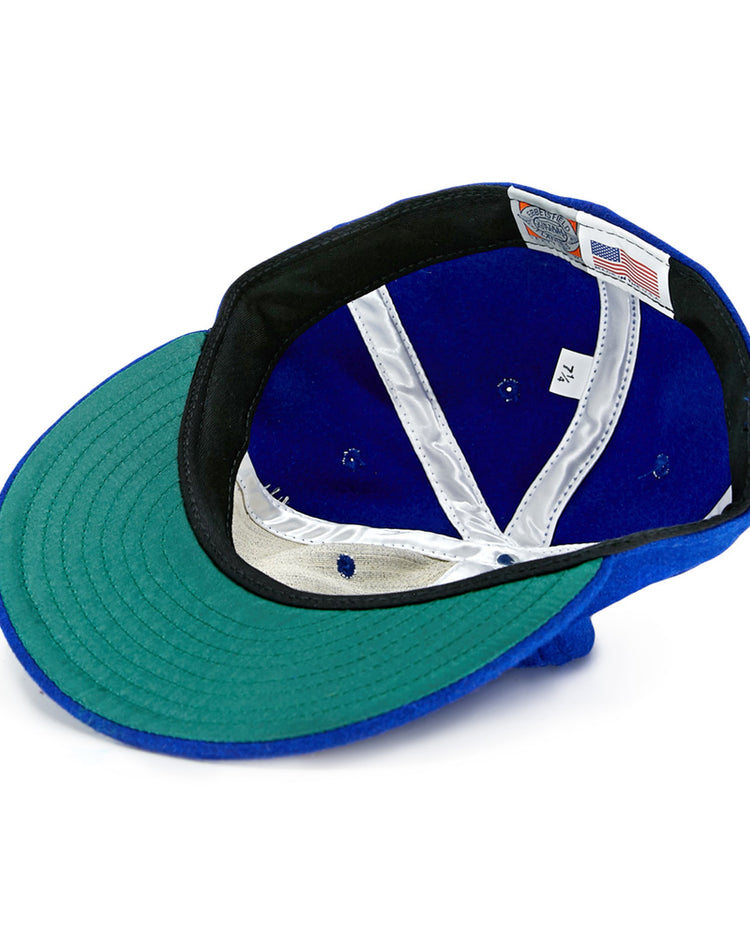 The EFF Memphis Red Sox 1944 Vintage Ballcap is shown upside down, revealing its green brim underside, black band, white interior labels, silver lining, and an American flag tag—just like the classic Negro American League style.