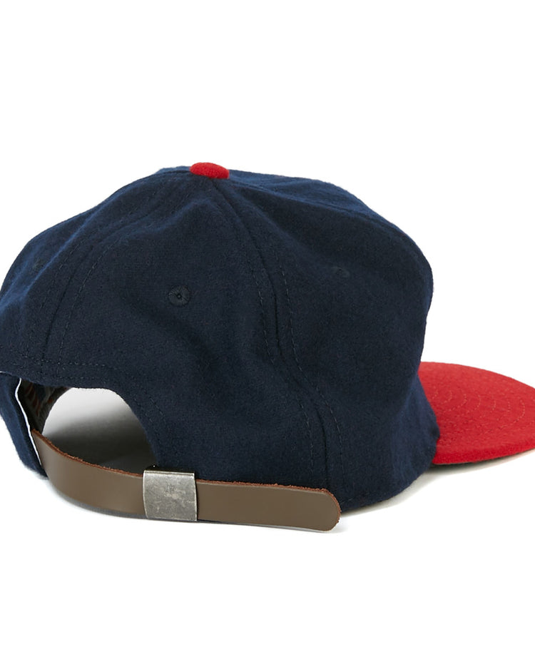 The EFF Milwaukee (AA) 1951 Vintage Ballcap is a navy blue wool cap with a red brim and button, shown from the back. This authentic reproduction features a brown leather adjustable strap and metal buckle.