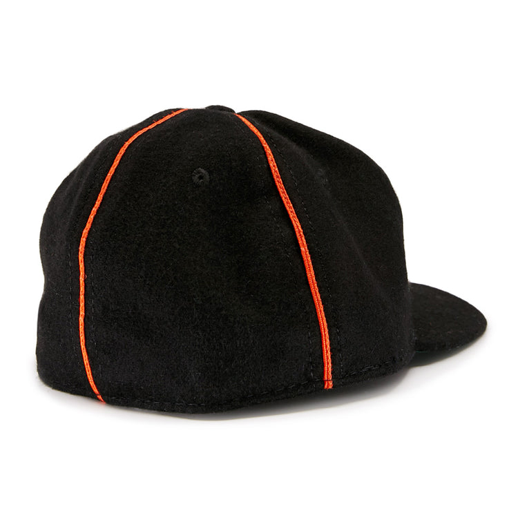 The EFF Wichita Monrovians 1925 Vintage Ballcap, inspired by classic Negro Leagues designs, features two vertical orange stripes running from the top button to the brim as seen from the back.