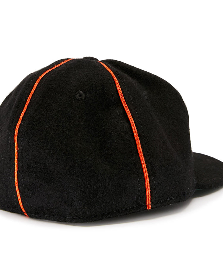 The EFF Wichita Monrovians 1925 Vintage Ballcap, inspired by classic Negro Leagues designs, features two vertical orange stripes running from the top button to the brim as seen from the back.