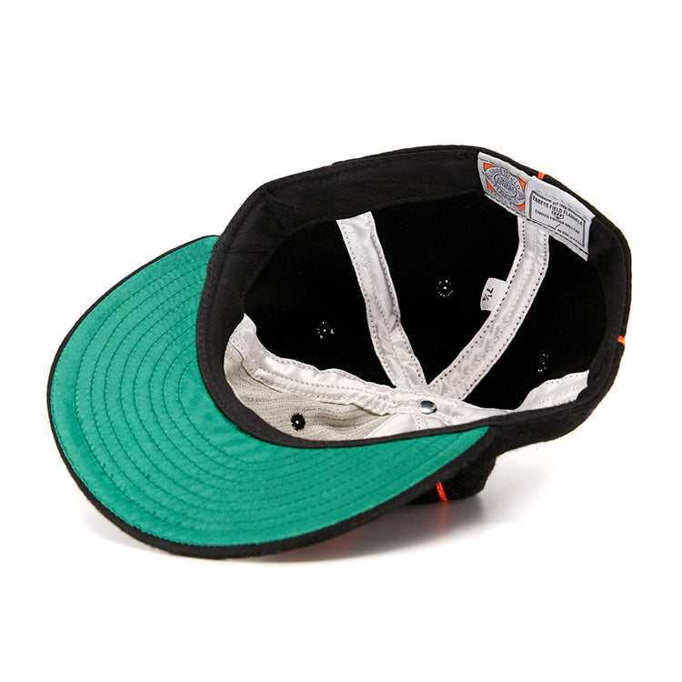 Turned inside out, the Wichita Monrovians 1925 Vintage Ballcap by EFF reveals a black sweatband, white inner lining, green underside of the brim, and sewn-in labels—showcasing vintage style inspired by classic Negro Leagues caps.