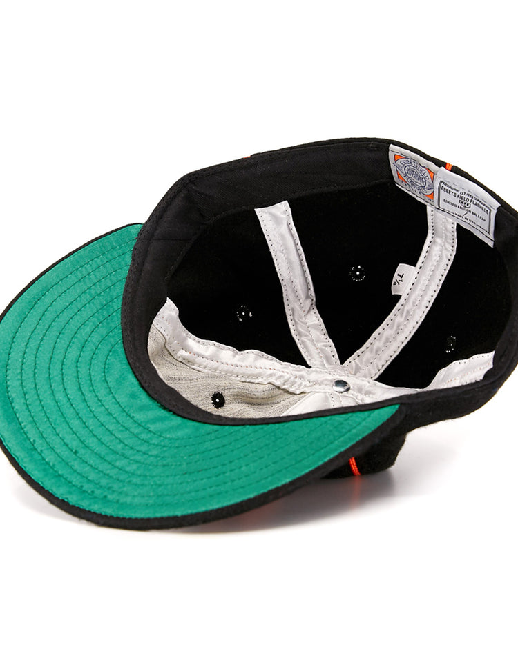 Turned inside out, the Wichita Monrovians 1925 Vintage Ballcap by EFF reveals a black sweatband, white inner lining, green underside of the brim, and sewn-in labels—showcasing vintage style inspired by classic Negro Leagues caps.