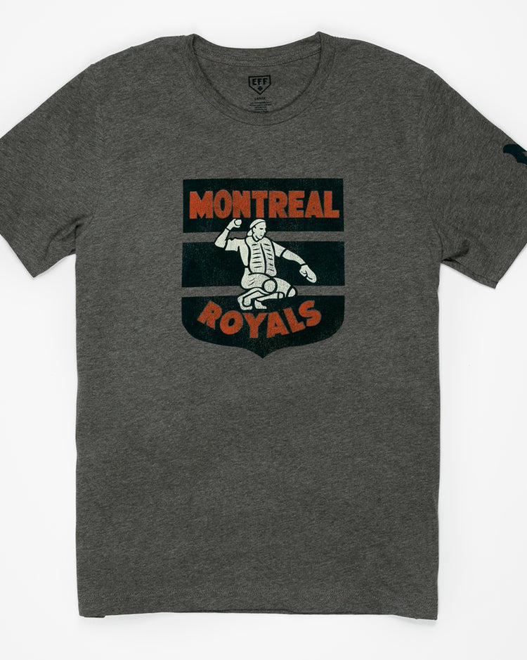 The EFF Montreal Royals 1946 T-Shirt is heather gray with a vintage-style catcher logo in white and orange on the chest, celebrating Dodgers prospect history, plus a small dark graphic on the left sleeve.