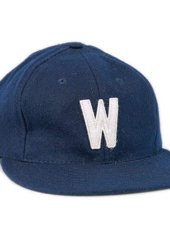 The Ebbets Field Flannels University of North Carolina Wilmington 1961 Vintage Ballcap is a navy wool cap with a white ‘W’ embroidered on the front, shown against a plain white background.