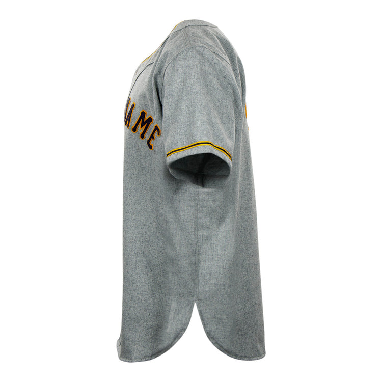 A side view of the EFF University of Notre Dame 1956 Road Jersey shows classic gray fabric with yellow sleeve trim and brown partial chest text, capturing the authentic Collegiate Team style.