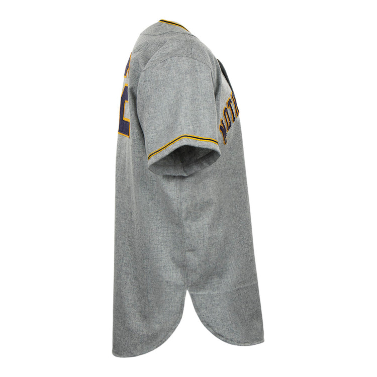 Side view of the EFF University of Notre Dame 1956 Road Jersey in gray, featuring yellow and purple trim on sleeves and collar. POTATO and number 22 appear on the back, emphasizing its Collegiate Team Authentic style.